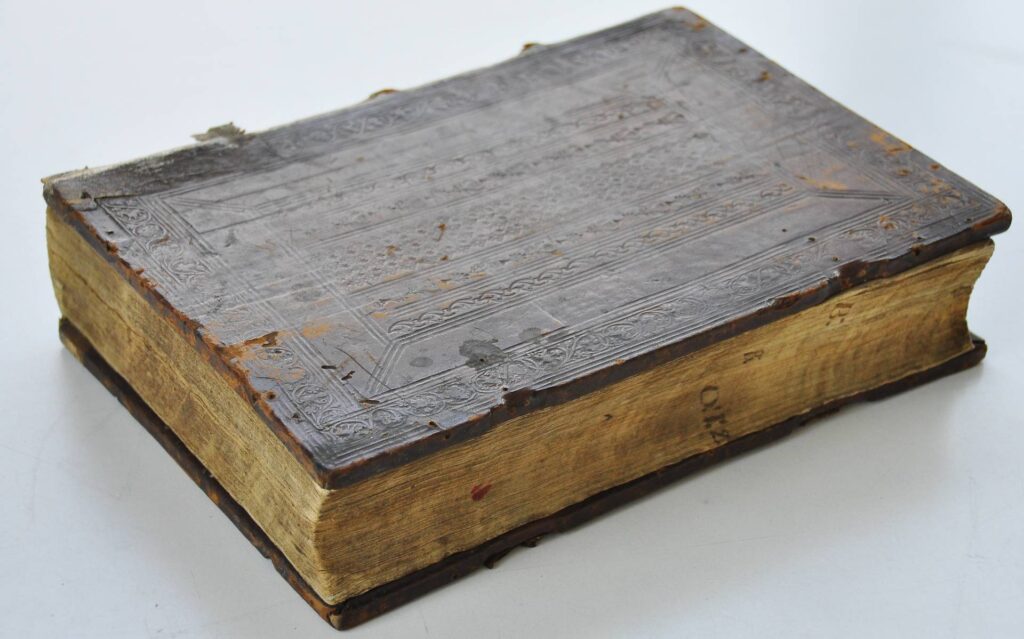 Na zdjęciu kodeks - zamknięty starodruk.Zdjęcie zrobione "izometrycznie". Oprawa ciemnobrązowa