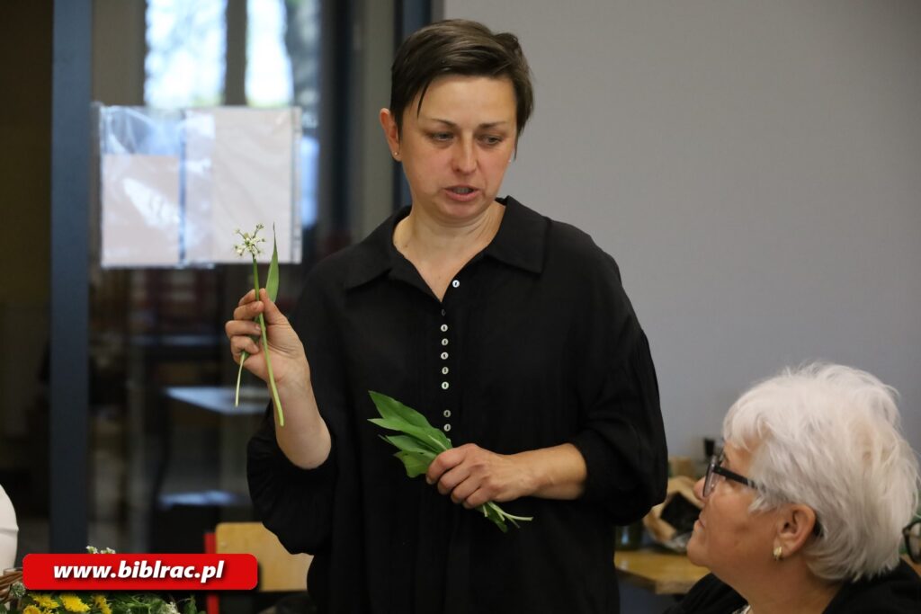 Zdjęcie przedstawia kobietę z krótkimi włosami w koszuli trzymającą w w dłoniach jakieś zioła.